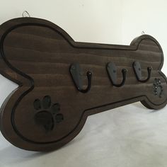 a wooden sign with dog paw prints on it's front and back sides, hanging from the wall