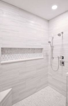 a white tiled bathroom with shower, sink and bathtub in the corner is shown