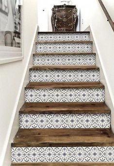 the stairs are painted with white and blue designs on them, along with a suitcase