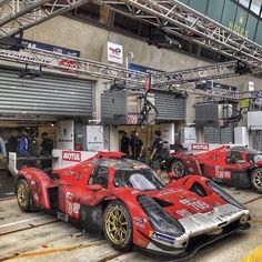 some racing cars parked in front of a building