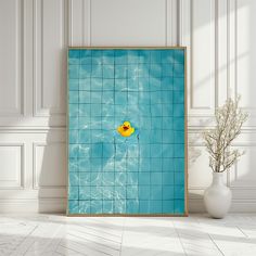 a blue tiled wall with a yellow rubber duck floating in the water next to a white vase