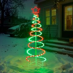 a lighted christmas tree in front of a house