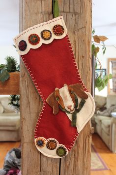 a christmas stocking hanging on a wooden post with a dog in the stockings and other decorations