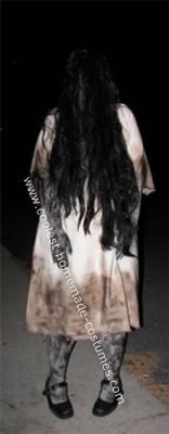 a woman with long hair standing on the street at night wearing a dress that has been dyed black and white