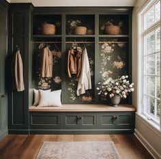 a room filled with lots of green cabinets next to a white rug and flowers on the wall