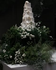 a wedding cake with white flowers and greenery