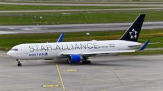 a large jetliner sitting on top of an airport tarmac with the word star alliance painted on it