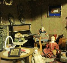 there are many dolls in this room with an old piano and other items on the table