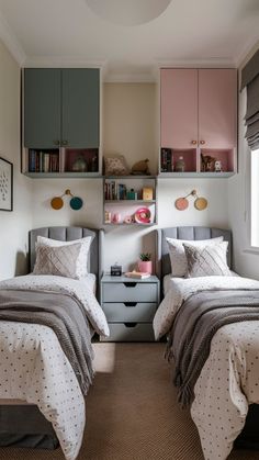 two twin beds in a bedroom with pink and gray accessories on the headboard, along with bookshelves