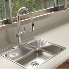 a stainless steel kitchen sink in front of a window