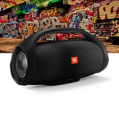 the jbl boom portable speaker is in front of graffiti