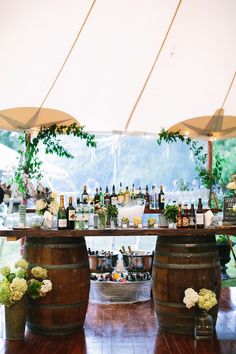 an outdoor bar set up with wine bottles and flowers