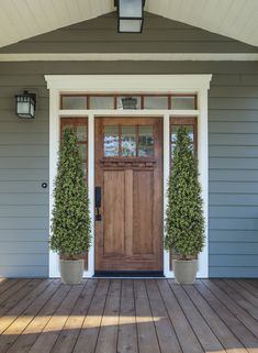 two potted plants are on the front porch