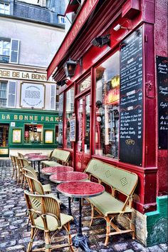 the outside of a restaurant with tables and chairs in front of it on a cobblestone street