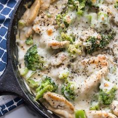 a skillet filled with chicken and broccoli covered in cheese