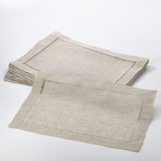 two linen placemats on a white surface