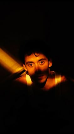 a man is looking at the camera in the dark