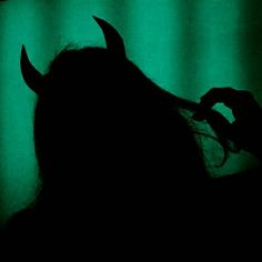 the silhouette of a woman with horns on her head