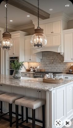 a large kitchen with white cabinets and marble counter tops, two stools in front of the island