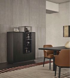 a dining room table with brown chairs and a black cabinet