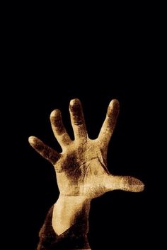 a person's hand is shown in sepia on a black background with the words,