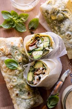 two wraps filled with vegetables on top of a wooden table