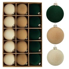 an assortment of christmas ornaments in a wooden box with green and white baubles