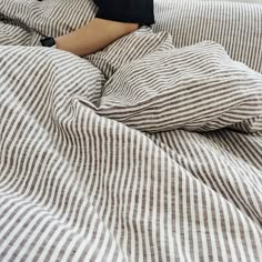 a person laying in bed with their feet on the pillow and covers folded over them