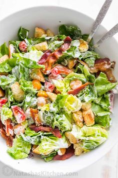 a white bowl filled with lettuce and bacon salad