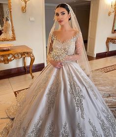 a woman in a wedding dress standing next to a mirror wearing a tiara and veil