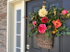 a basket filled with flowers hanging from the side of a door