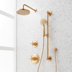 a gold shower faucet with thermostaer and hand shower head in an all white bathroom