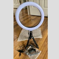 a white ring light sitting on top of a wooden floor