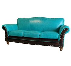 a blue leather couch sitting on top of a white floor next to a wooden frame