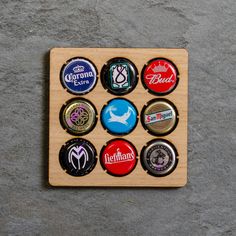 six bottle caps are arranged on a wooden board