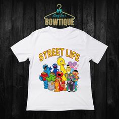 the sesame street life t - shirt is hanging on a wooden wall with an image of characters