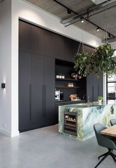 an open kitchen with black cabinets and marble counter tops is shown in this modern loft apartment