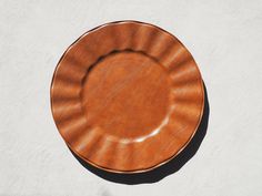 a brown plate sitting on top of a white wall