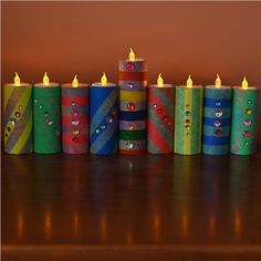 there are many different colored candles on the table