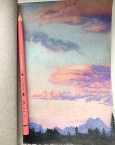 a pink pencil sitting on top of a piece of paper next to some watercolor