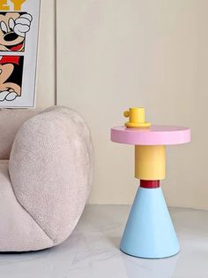 a mickey mouse chair sitting next to a table with a toy on top of it