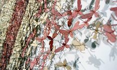 an abstract painting with red, yellow and green leaves on white wallpaper in the background