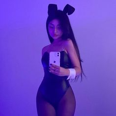 a woman in bunny ears holding a cell phone