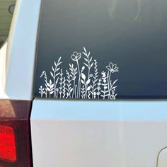 a white car with flowers on it's side and the back window is open