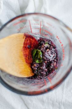 a blender filled with blueberries and spinach on top of a white cloth