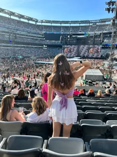 a woman in a white dress standing at the end of a stadium