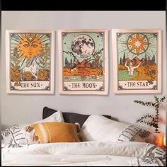 three sun tarot cards hanging on the wall above a bed with pillows and blankets