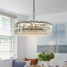 a chandelier hanging from the ceiling in a room with white walls and furniture