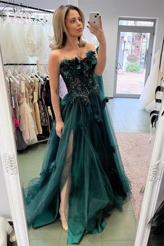 a woman taking a selfie in front of a mirror wearing a dress with flowers on it