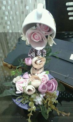 a bouquet of flowers sitting on top of a purple plate next to a piano keyboard